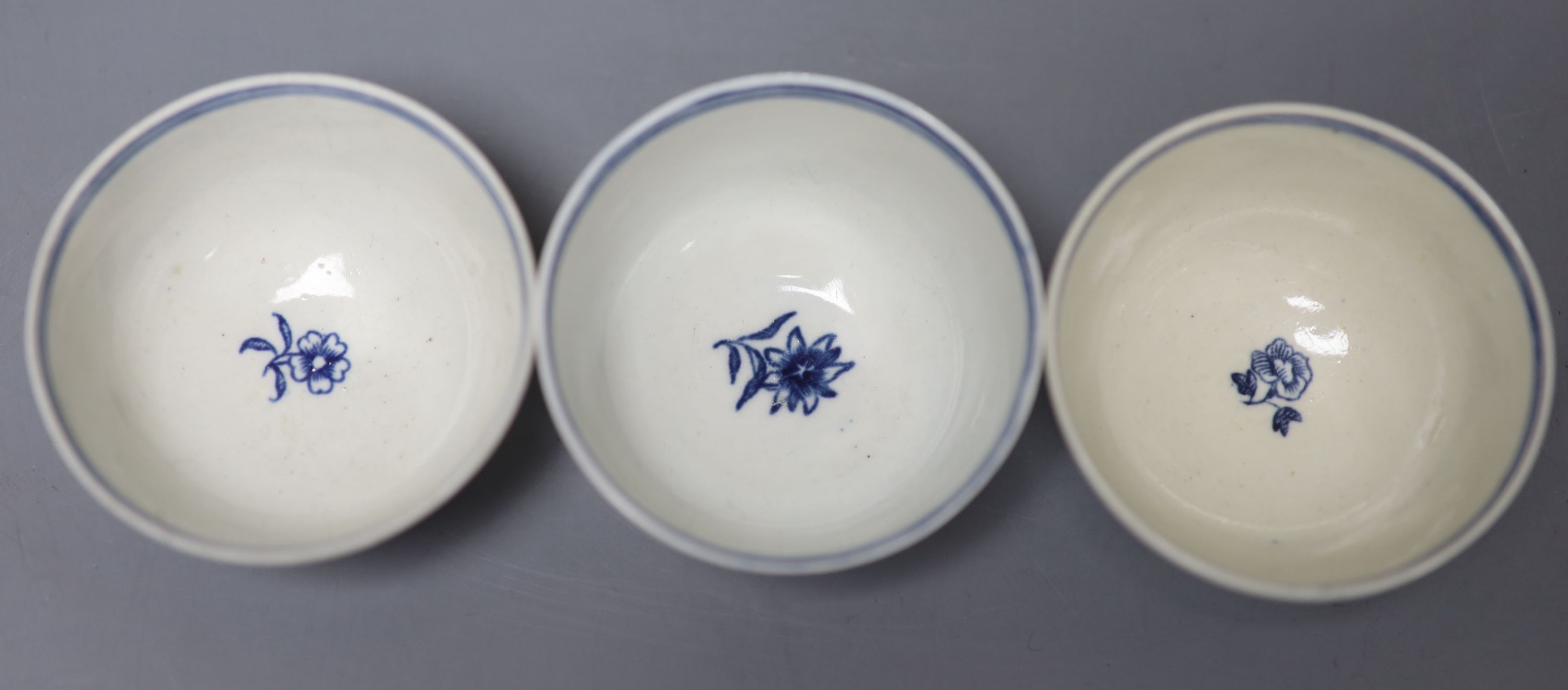 Three 18th century Worcester tea bowls and saucers, two printed with Three Flowers and one printed with the Fence pattern most with cre